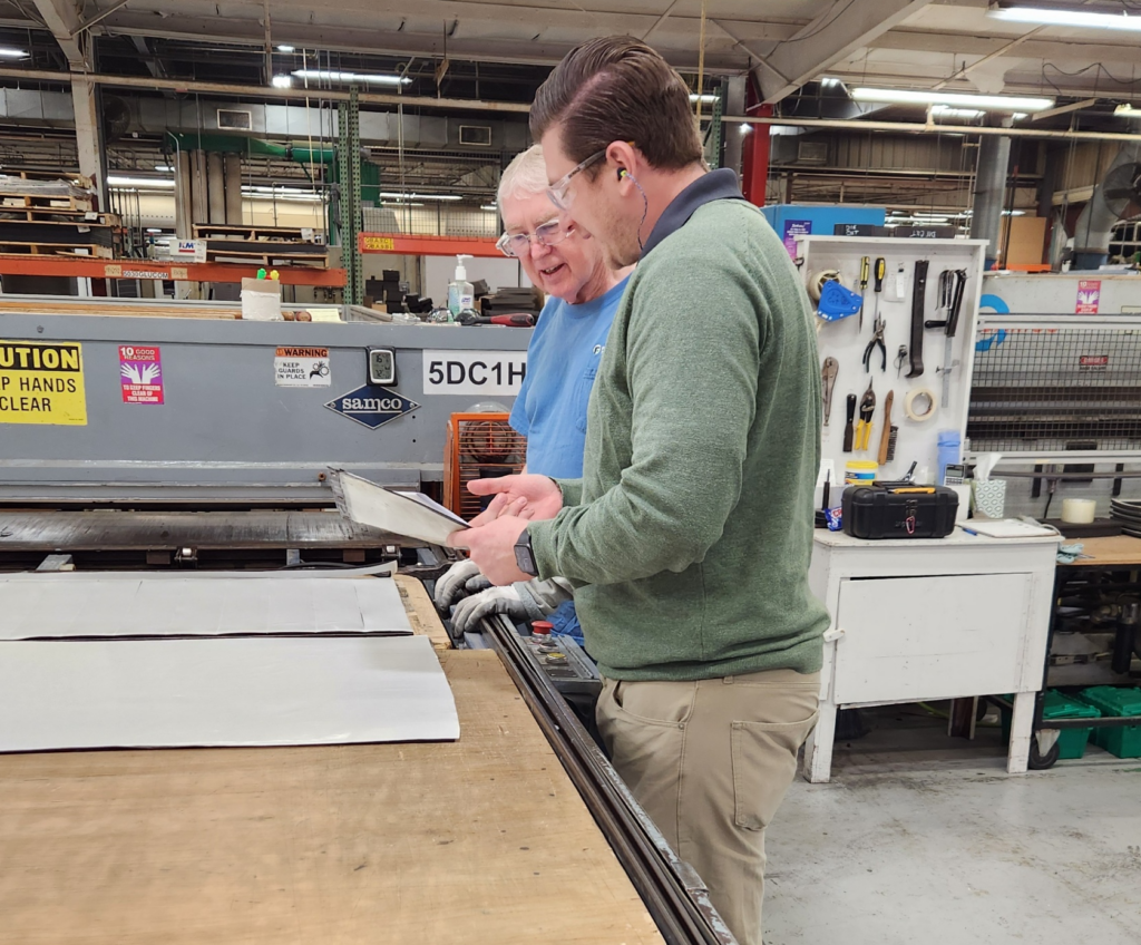 Two men reviewing parts on production floor